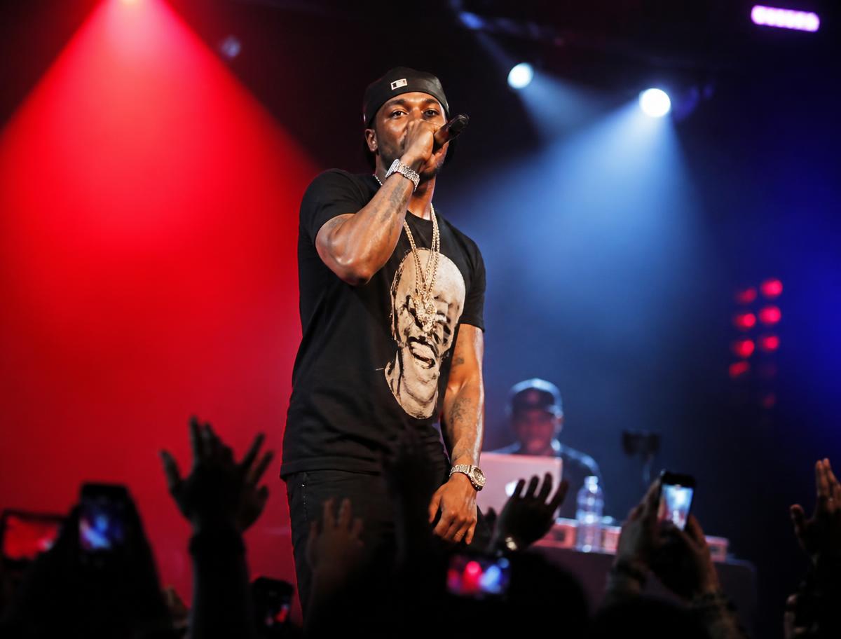 Rapper performing under red and blue stage lights at a Space Tunez showcase